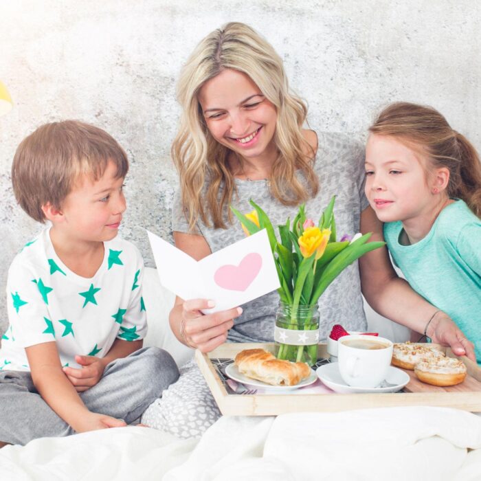 Mother´s-Day-two-children-surprise-their-mother-with-breakfast-in-modern-bed